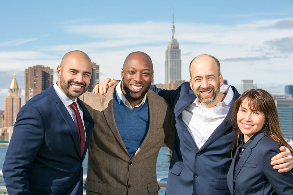 Spring Bank Team smiles with Manhattan landscape in background